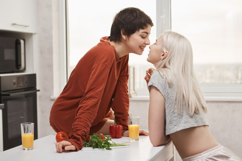Lesbians kissing next kitchens table