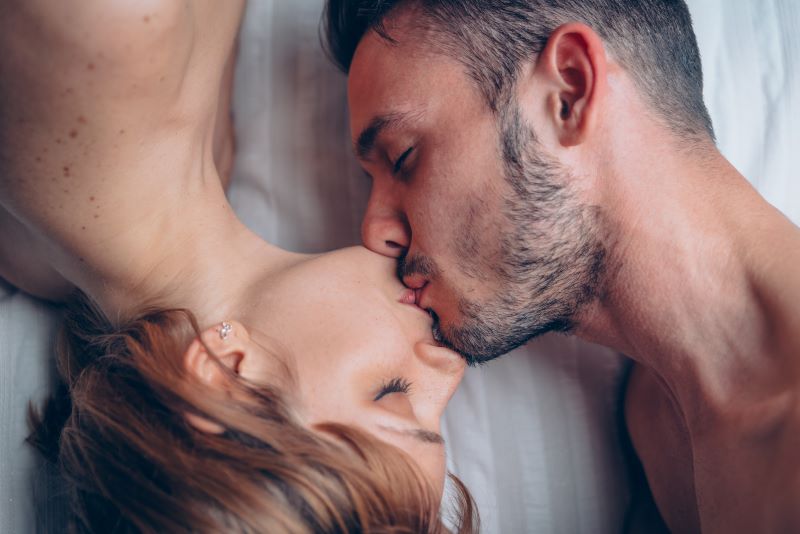 Couple having romantic kiss in bed