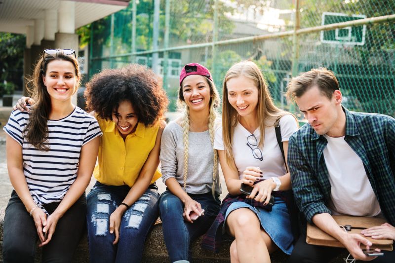 Diverse friends hanging out in park