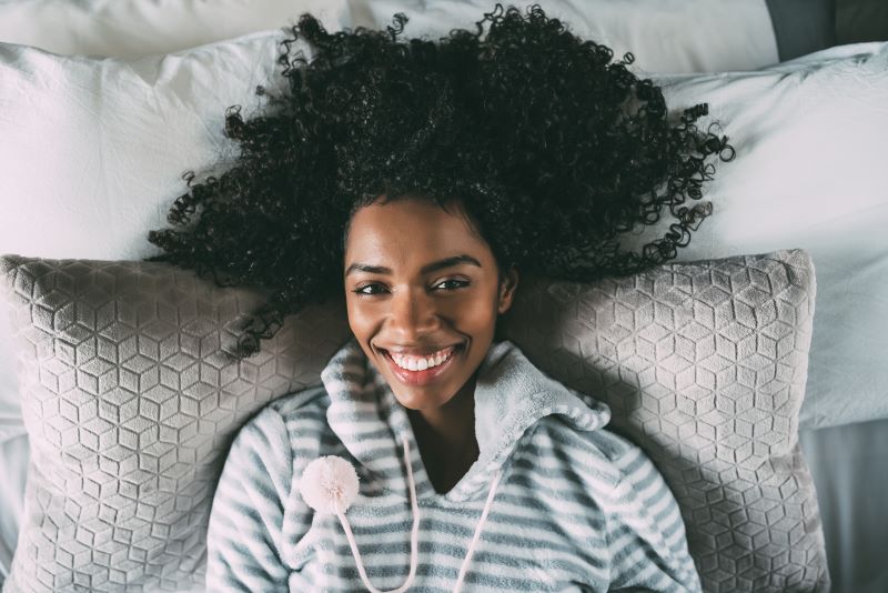 Happy woman smiling in bed