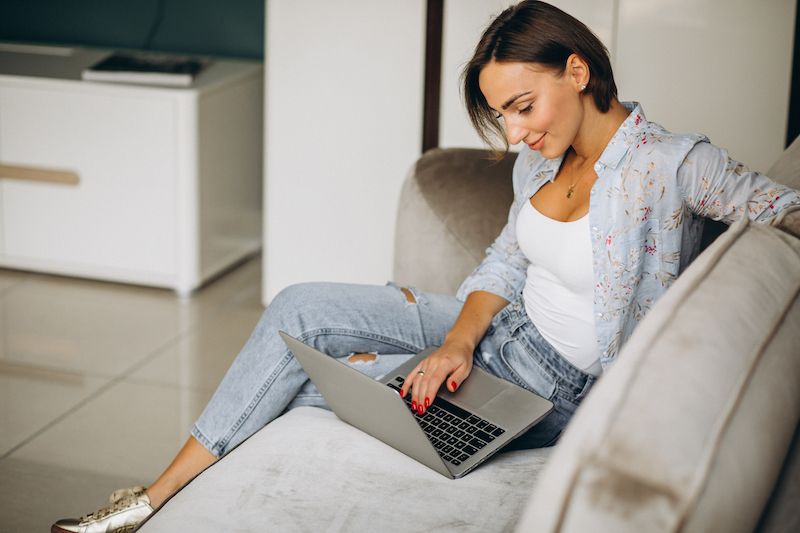 Woman in the sofa chatting online 