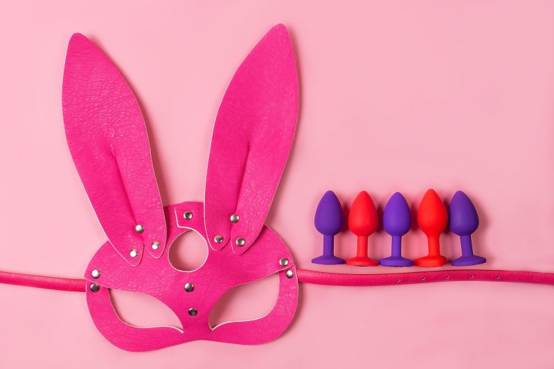 Anal plugs and bunny mask on pink background