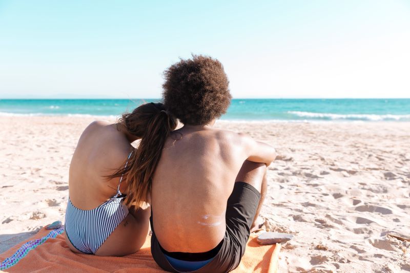 Dos de couple assis sur la plage