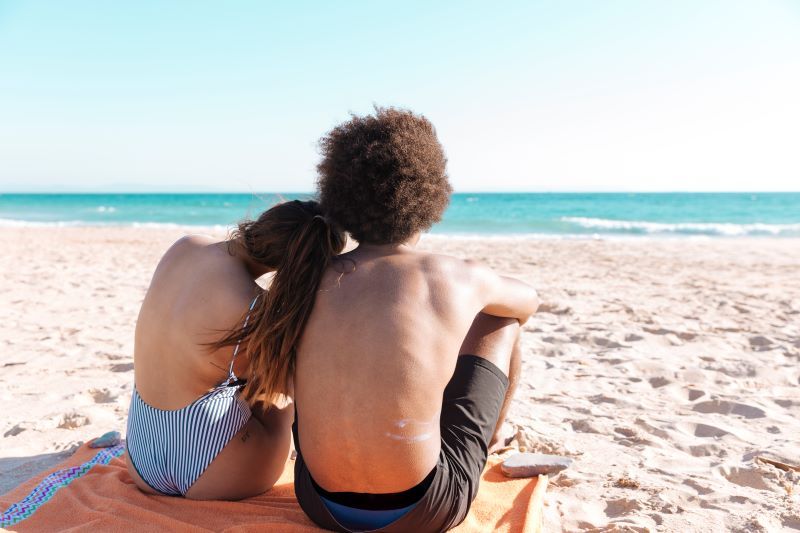 Back of couple sat on beach