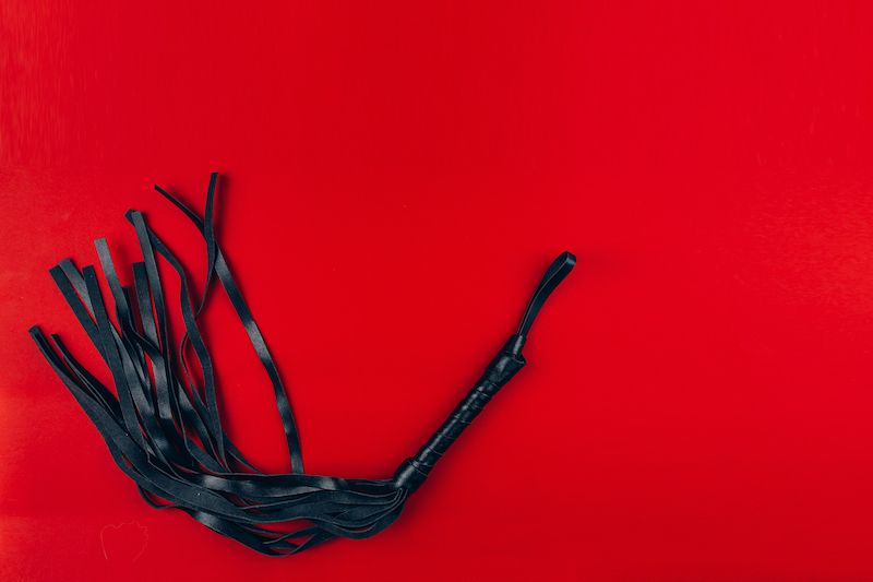 Black flogger on red background