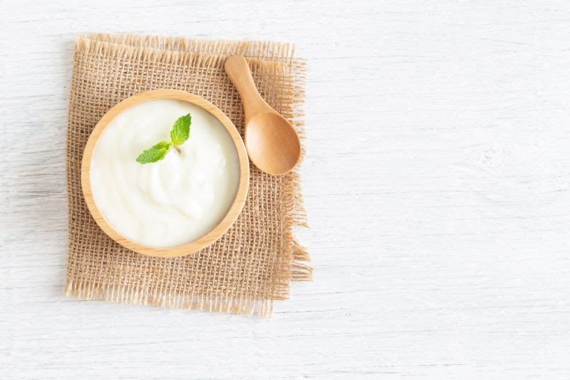 Bowl of yogurt on a wooden mat