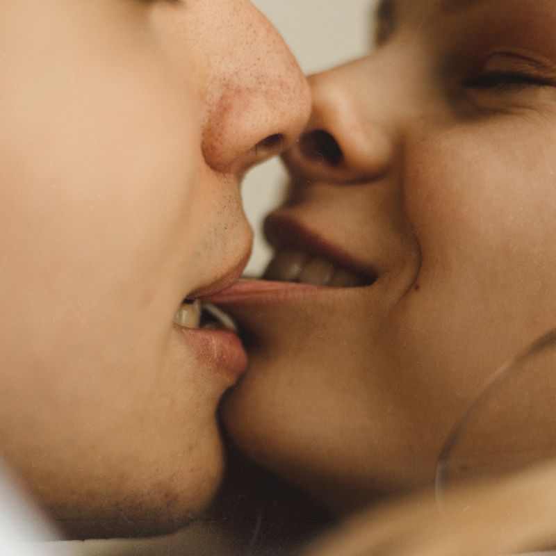 Close up passionate couple kissing lip bite