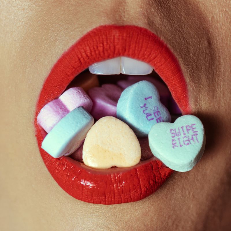 Close up woman's mouth red lipstick with sweets