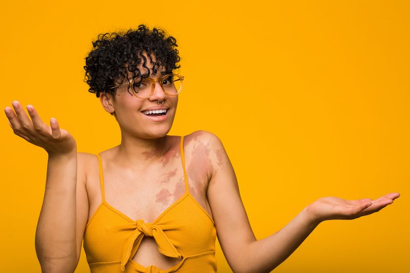 Confused young woman shrugging her shoulders