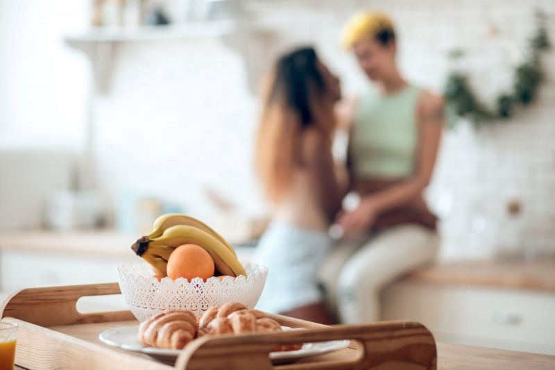 Couple discutant dans la cuisine près d'un bol de fruits