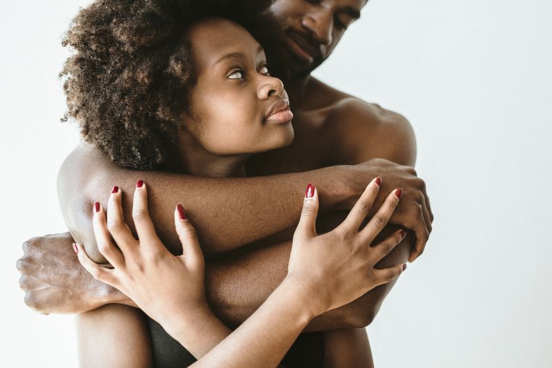 Couple embracing from behind white background