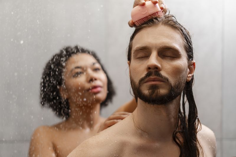 Couple giving scalp massage in shower