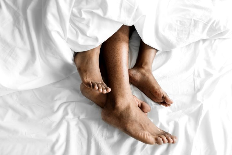 Couple in bed sleeping with feet showing