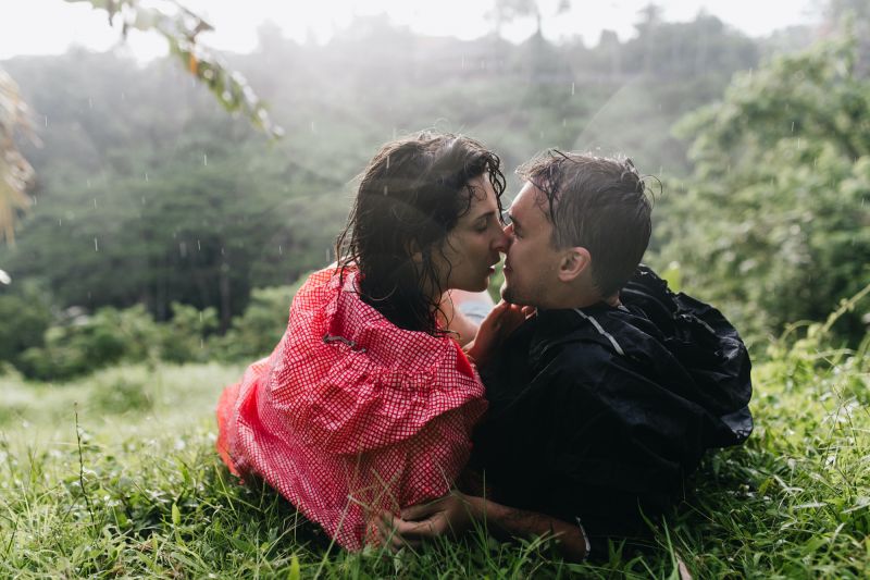 Couple s'embrassant sur l'herbe sous la pluie