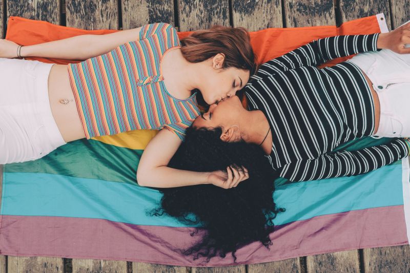 Couple kiss on colourful blankets outdoors