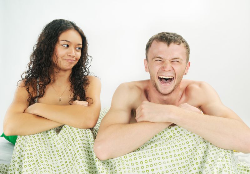 Couple laughing under duvet
