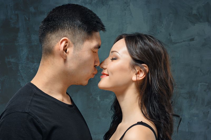 Couple leaning in for kiss and squinting