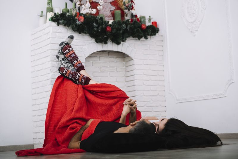 couple on floor near fireplace christmas time