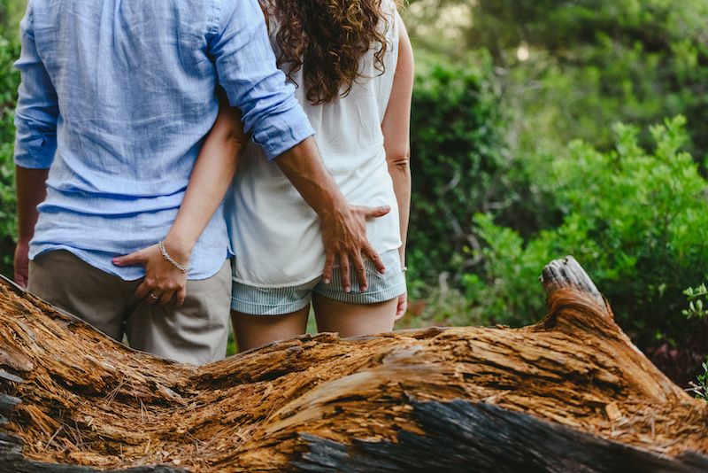 Couple outdoors touching each other's butts