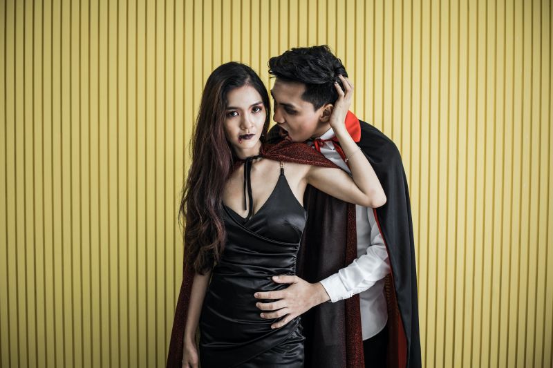 Couple posant en costume de vampire halloween