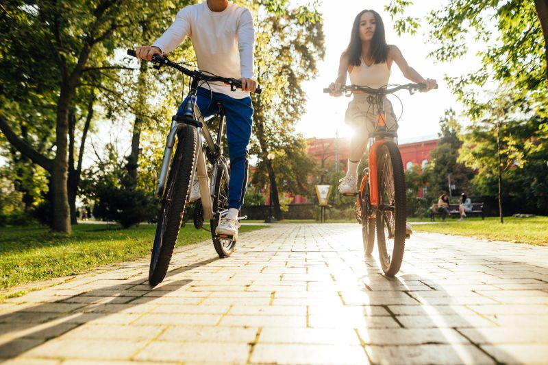 Couple cycling in the park in the sun