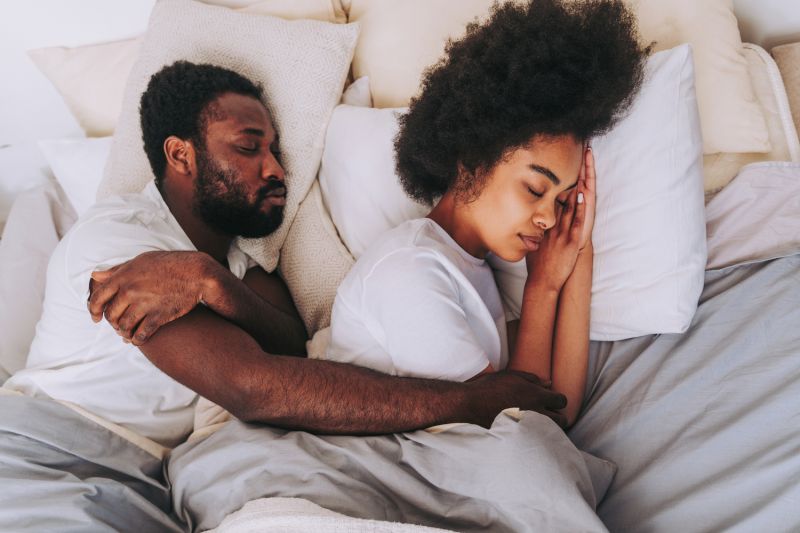 Couple sleeping and embracing in bed