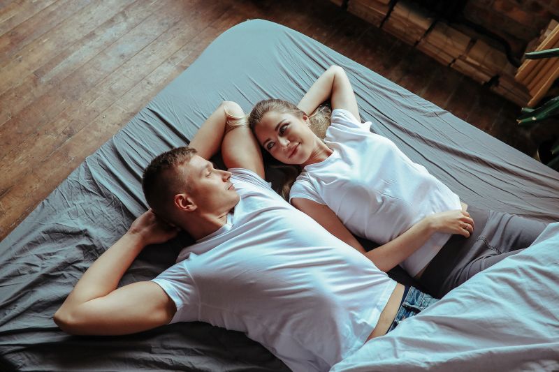 Couple souriant détendu au lit