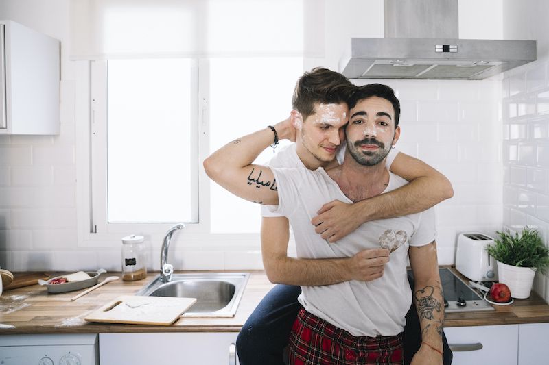 Couple with messy faces embrace in the kitchen