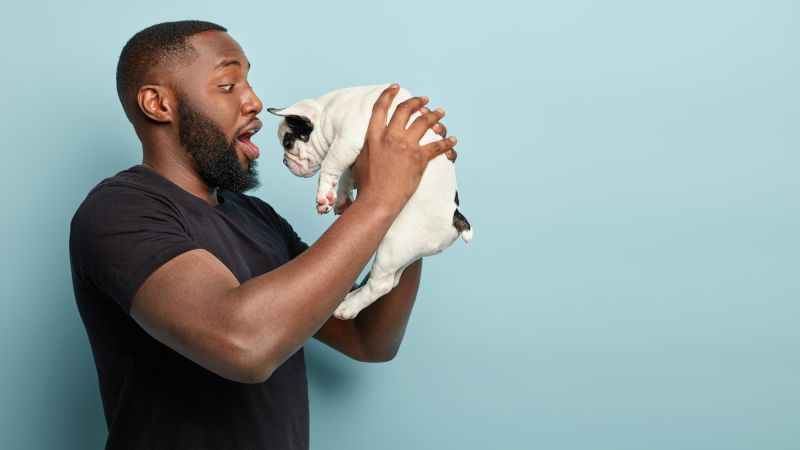 Excited man holding up dog