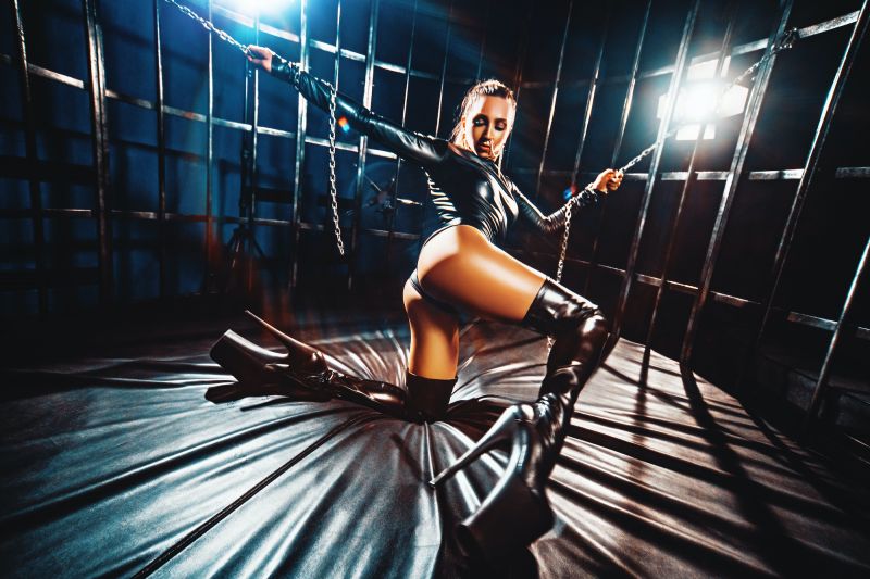 Female dancer in cage in BDSM outfit