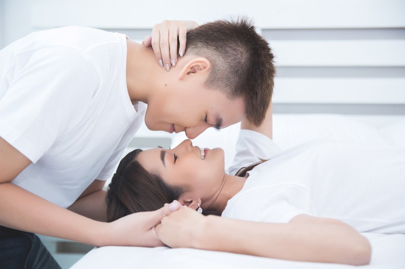 Couple s'embrassant au lit