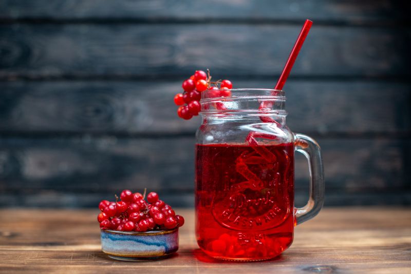 Fresh cranberry juice in glass with straw