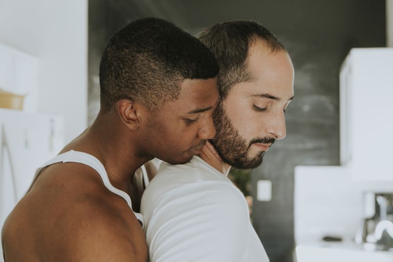 Gay couple hugging in kitchen