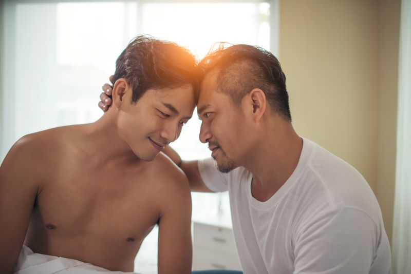 Gay couple in bed romantic