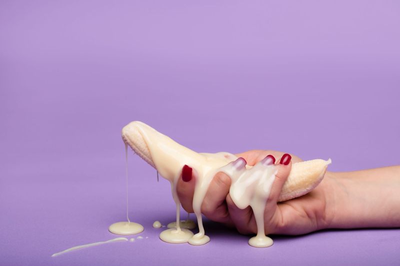 Hand holding banana with creme ejaculation concept