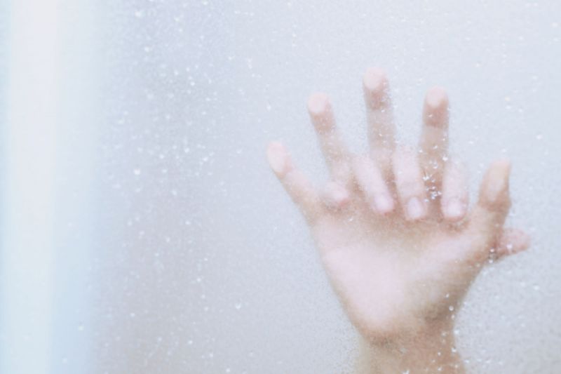 Hands on steamy shower door