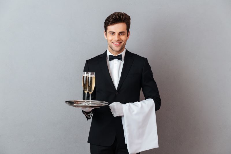 Attractive waiter holding champagne