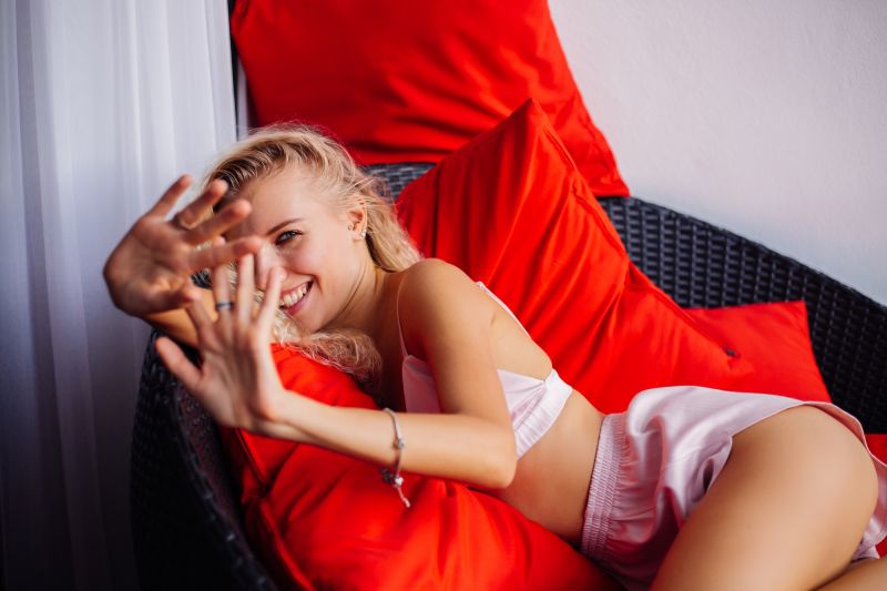 Happy young blonde woman on chair