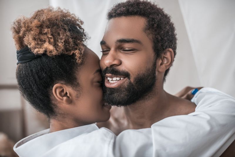 Heureux couple étreignant et souriant à la maison