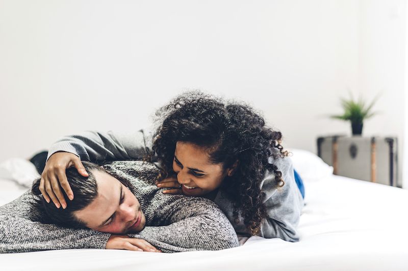 Happy couple in bed laughing