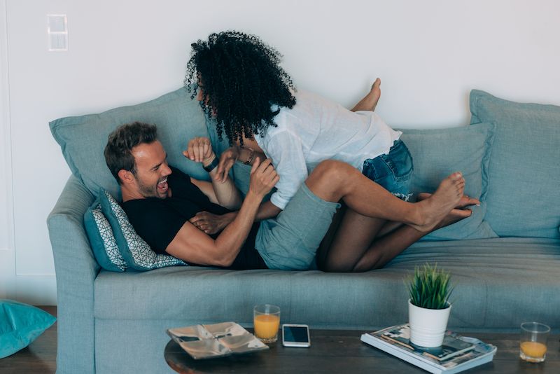 Happy young couple play fighting at home