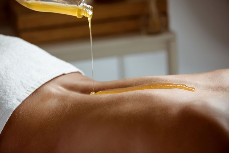 Honey being poured on woman's back