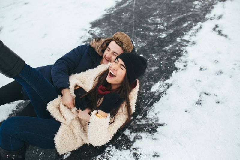 Couple riant tombé sur la glace
