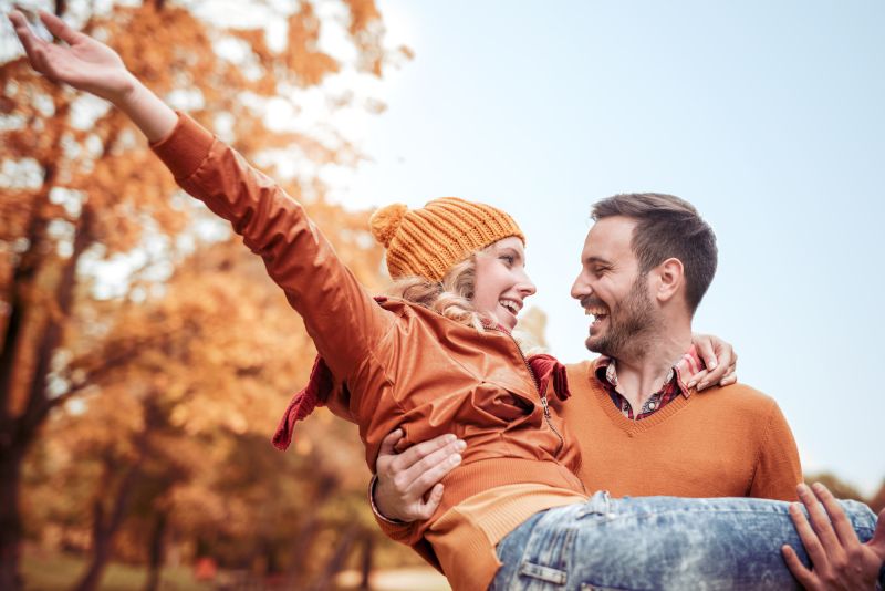 Couple qui rit à l'extérieur sur fond d'automne