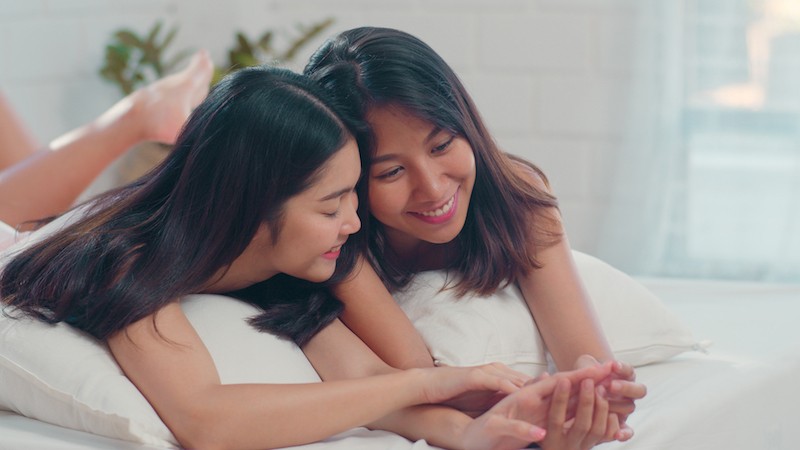 Two women couple on bed