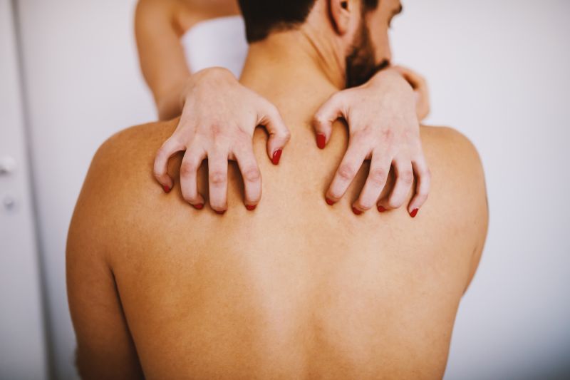 Amoureux à la maison les mains de la femme sur le dos de l'homme