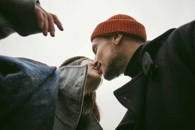 Low view couple in hats kissing outside