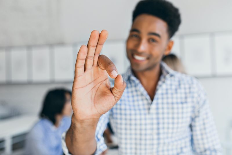 Man in an office making okay sign