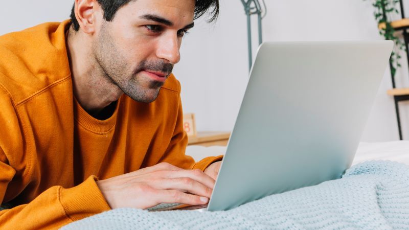 Man using laptop in bed