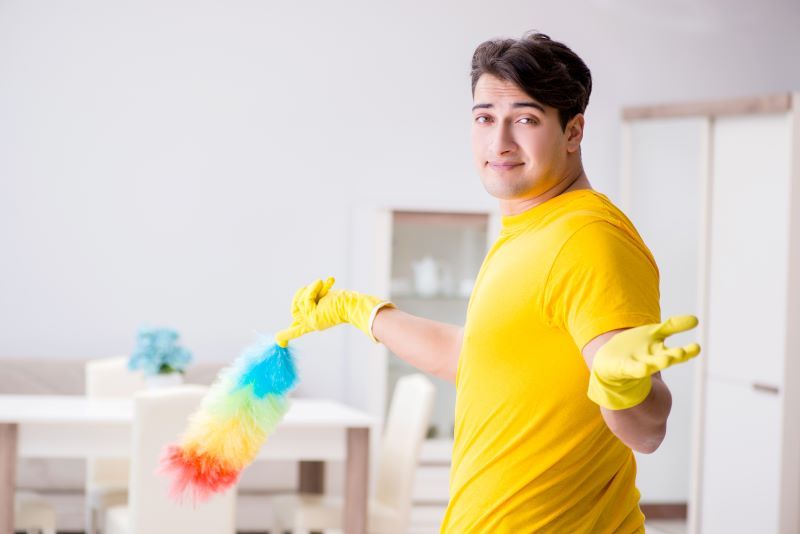 Man cleaning with feather duster